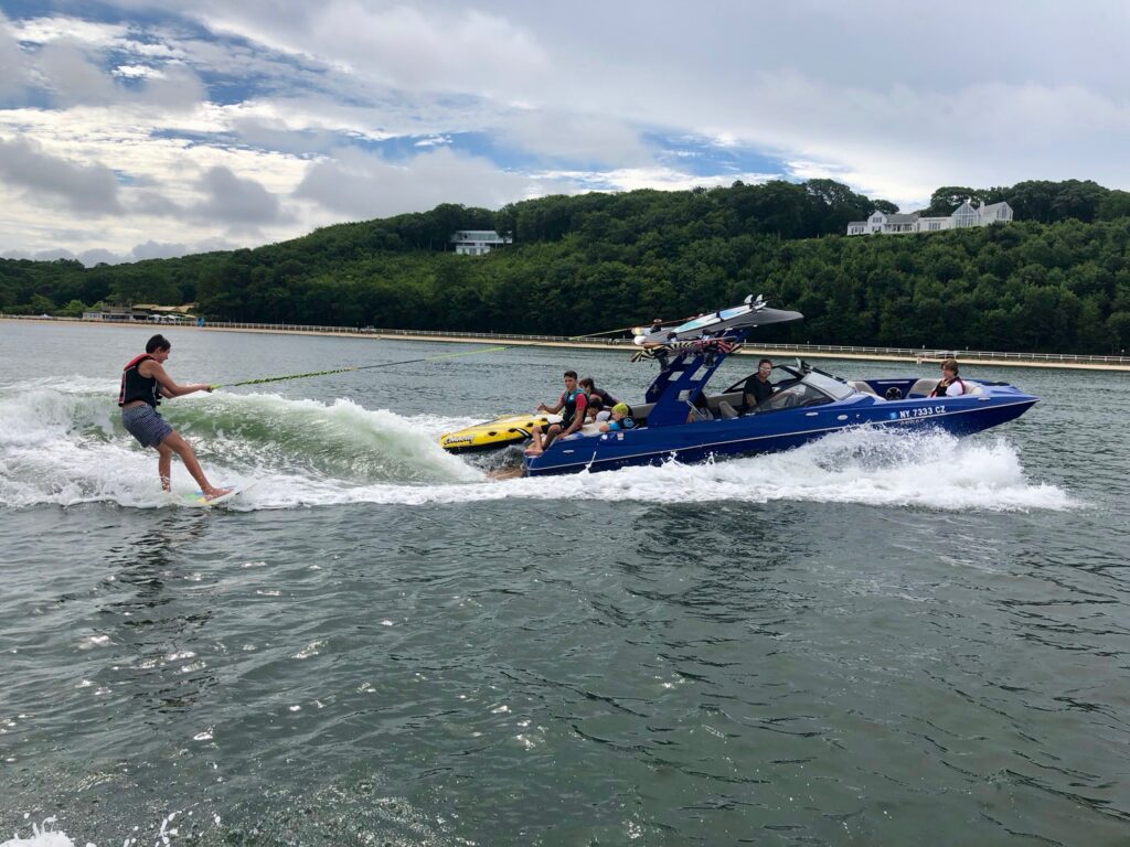 wake surfing with peconic water sports in front of sunset beach hotel during summer